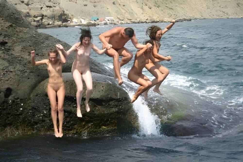 Mens and girls nudists on a beach - In naturism, people are equal regardless of circumstances